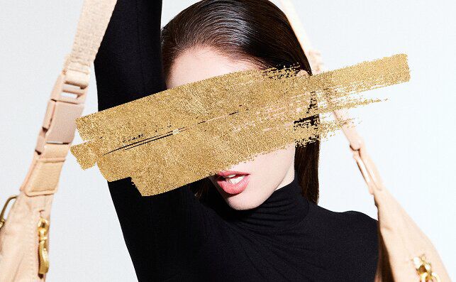 Woman holding bag with gold paint across the image